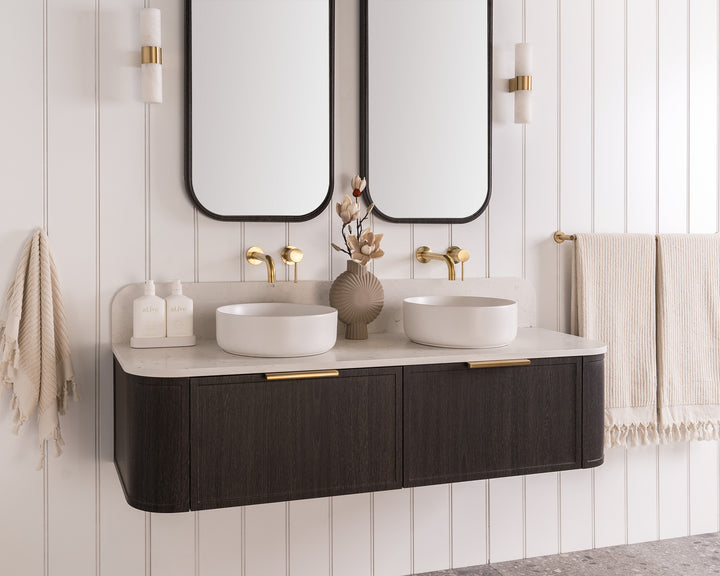 Flo Wall Hung Vanity - Flo 1500 Double Bowl, Estella Oak, Mont Blanc Cherry Pie benchtop. Brushed Brass Francis Handles. Quinn Mirrored Cabinets, Estella Oak. Margot Above Counter basins, Matte White. Bloom Tapware, Light Brushed Brass